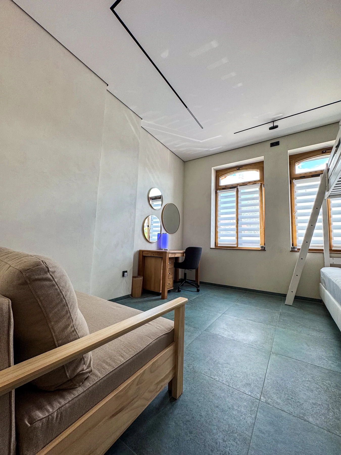 Schlafzimmer mit Hochbett, Schlafsofa und Arbeitsplatz aus der Gegenperspektive
